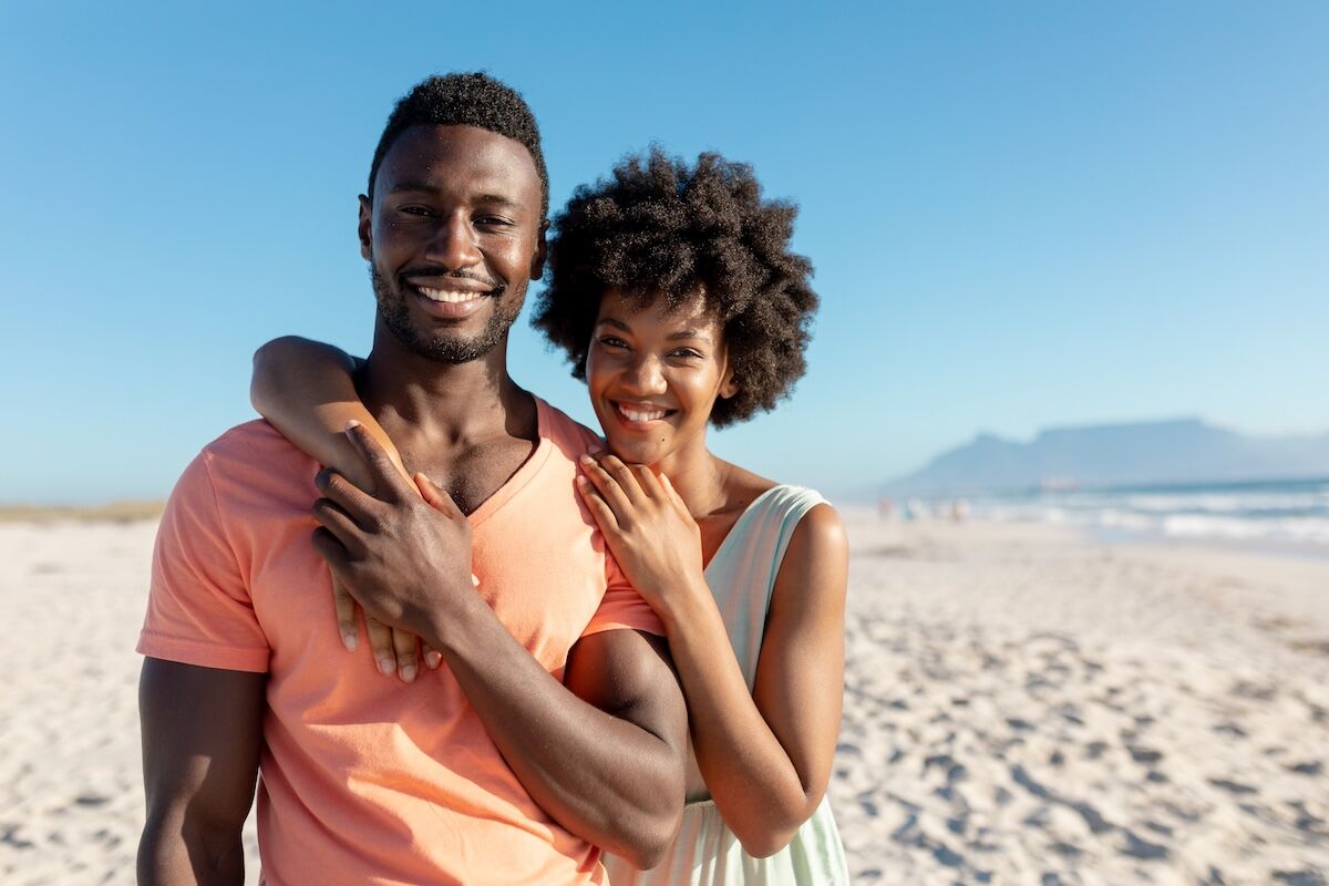 Smiling couple hugging on the beach
